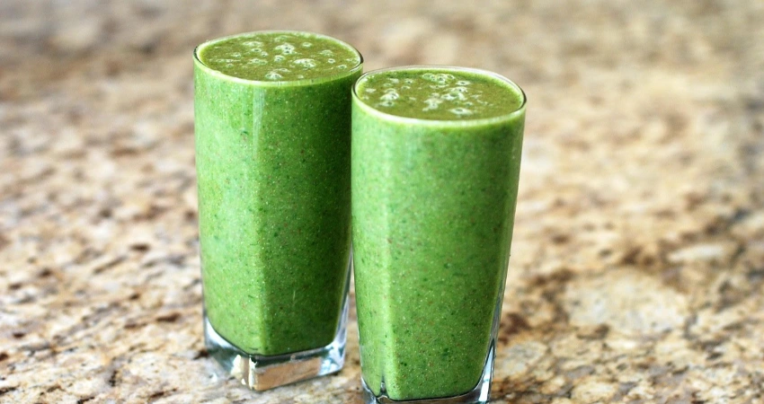 Chlorella-Algen und frischer Koriander auf Holztisch für natürliche Schwermetallausleitung und Detox